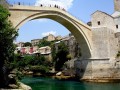 Bośnia i Hercegowina to kraj położony w środkowej części Półwyspu Bałkańskiego. Na chwilę obecną, po podpisaniu traktatu pokojowego, którym zakończyła się wojna domowa w Bośni i Hercegowinie w latach 1991-1995, w skład państwa wchodzi Republika Serbska (Republika Srpska) oraz Bośniacko - Chorwacka Federacja Bośni i Hercegowiny. Kraj posiada jedynie 17 km dostęp do Adriatyku, który rozdziela na dwie części Chorwację. Waluta jaka obowiązuje w tym kraju to konwertybilna marka, która zgodnie z kursem walutowym jest równa kwocie 2 złote i trzy grosze. Paszport nie jest wymagany dla państw członkowskich Unii Europejskiej, jednak sam dowód osobisty może nie wystarczyć w przypadku bezpłatnej pomocy medycznej, niektórych banków czy transferów pieniężnych. W takich wypadkach do dyspozycji Polaków jest ambasada w stolicy kraju, którą jest Sarajewo, gdzie polski konsul powinien udzielić nam pomocy w spornych kwestiach.


Historia


Państwo te od 11 roku p.n.e. należało do Cesarstwa Rzymskiego. W VII wieku, na tereny wkroczyli Słowianie. Nieprzerwanie, od XIII wieku, Bośnia i Hercegowina była najeżdżana przez Węgry, Turcję i Austro - Węgry. W 1918 roku Bośnia, Chorwacja, Serbia i Słowenia weszły w skład późniejszej Jugosławii. Gdy w 1991 roku, Jugosławia się rozpadła, nastąpiła jugosłowiańska wojna domowa. Powodem jej wybuchu była próba usamodzielnienia się poszczególnych republik. Gdy w 1992 roku Bośnia i Hercegowina proklamowała swoją niepodległość, konflikt jugosłowiański nasilił się. Dochodziło do regularnych potyczek między Chorwatami, Serbami, Bośniakami. Skutkiem tego były ogromne czystki etniczne, ginęli ludzie zarówno o narodowości chorwackiej jak i serbskiej. Do zakończenia trwającej od 1991 roku wojny domowej doszło dopiero w 1995 roku.


Atrakcje turystyczne, wycieczki


Wydawać by się mogło, że kraj ten nie ma nic ciekawego do zaoferowania turystom. Wręcz przeciwnie. Turystyka w Bośni i Hercegowinie sukcesywnie się rozwija, oferując przybyłym liczne atrakcje. Dodatkowym bodźcem dla turystów z całej Europy są ceny. W Bośni i Hercegowinie, ceny pobytu wakacyjnego są nawet do 30 % niższe niż ceny proponowane w Chorwacji.

Jeżeli wybieramy się do Bośni i Hercegowiny aby rozkoszować się kąpielami nad Adriatykiem, musimy koniecznie udać się do Regionu Neum, który jako jedyny w kraju posiada dostęp do morza. Na turystów czeka tam zaplecze turystyczne, które pozwoli spędzić urlop w komfortowych warunkach. Głównym punktem pobytu w Bośni i Hercegowinie powinno być odwiedzenie stolicy. Sarajewo, bo o nim mowa, powoli staje na nogach, po ciosach jakie zadała wojna domowa. Zaobserwować w nim można mieszankę stylów architektonicznych. Będąc w stolicy warto zwiedzić tamtejsze meczety - o dziwo po wojnie, zachowało się ponad 60, kryty bazar Brusa Bezistan, w którym obecnie znajduje się muzeum oraz napawać oczy zabytkowymi domami. Równie ważnym elementem poznawania kultury tego kraju jest miejsce zwane Madziugorje (Madjugorje). Jest to miejsce kultu Matki Bożej Królowej Pokoju. Jeżeli jesteśmy miłośnikami dzikiej, pięknej przyrody koniecznie musimy wybrać się na wyprawę w dwa miejsca. Jedno z nich to Alpy Dynarskie. To miejsce idealne dla miłośników górskich wspinaczek, ponieważ mimo majestatycznego wyglądu, przejście po ich szczytach jest w zasięgu ręki. Mimo nazwy, góry te nie są zaliczane do pasma Alp, jednak w niczym nie ustępują jednym z najsłynniejszych gór w Europie. Kolejne, godne polecenia miejsce to rzeka Tara. Co prawda, przez teren Bośni i Hercegowiny przepływa 30 km tej rzeki, to jednak wystarczająca długość aby poznać smak górskiego raftingu na spienionych falach Tary. Ci, którym wystarczą same widoki, z pewnością również będą usatysfakcjonowani. Będąc w Bośni i Hercegowinie warto odwiedzić zabytek wpisany na listę UNESCO. Mowa o starówce w mieście Mostar, którego słynny Stary Most zasłużył sobie na wpisanie na tą zaszczytną listę. W Bośni i Hercegowinie znajdziemy również coś dla zakochanych par. Wystarczy udać się do małego miasteczka Tuzla. Mimo że słynne jest głównie z wydobycia soli w dawnych czasach, na językach wszystkich znalazło się w 2007 roku. Wtedy to właśnie pobito tutaj rekord świata w liczbie całujących się par. Jednocześnie zrobiło to blisko 7 tysięcy zakochanych.

Od niedawna Bośnia i Hercegowina ma cechy wspólne z Egiptem. Chodzi o piramidy, których odkrycie ogłoszono w 2005 roku. Trzy piramidy, noszące nazwy Bośniacka Piramida Słońca(Bosanska Piramida Sunca), Bośniacka Piramida Smoka (Bosanska Piramida Zmaja) oraz Bośniacka Piramida Księżyca (Bosanska Piramida Mjeseca), znajdują się w pobliżu miasteczka Visco. Aby móc pogłębić naszą wiedzę na temat zabytków tego kraju warto zainwestować w wycieczki, na których będzie przewodnik. Dzięki temu poznamy kraj od podszewki.


Plaże i sporty


Plaże dostępne tylko w regionie Neum. Głównie kamieniste lub betonowane. Sporty najczęściej uprawiane to sporty wodne w regionie Neum, gdzie na turystów czekają narty wodne, skutery czy windsurfing. W pozostałych częściach kraju można aktywnie uprawiać turystykę rowerową, znajdzie się również coś dla amatorów wspinaczki po Górach Dynarskich.


Noclegi


Cały kraj wyposażony jest w bogatą bazę noclegową. Bałkany w dalszym ciągu przyciągają turystów, więc gospodarka kraju na tym zyskuje. Jeżeli wybierzecie się w region Neum, warto odwiedzić hotel Neum, który zapewni nam komfortowy wypoczynek w odpowiednio wyposażonych we wszystkie udogodnienia pokojach. Dodatkowo na miejscu czekają na nas miejsca przeznaczone do gier zespołowych, w pobliżu znajduję się również wypożyczalnia sprzętu wodnego i oczywiście plaża, na której możemy nabywać adriatyckiej opalenizny.


Kuchnia


Kuchnia bośniacka jest bardzo naturalna, obfitująca w warzywa i różnego rodzaju mięsa. Warto spróbować nietypowych gołąbków (dolma sogan), które tak jak nasze składają się z ryżu i mięsa, ale zawijane są w cebulę. Ryby, które robią największą furorę to dorada i labrak.


Klimat


W regionie Neum panuje klimat śródziemnomorski, czyli możemy opalać się w promieniach słońca, które przeważnie przekracza 25 stopni Celsjusza w okresie letnim. W pozostałej części kraju nie jest aż tak ciepło, jednak ogólnie klimat sprzyja odwiedzaniu Bośni i Hercegowiny o każdej porze roku, gdyż nie grożą nam tu zimy stulecia.