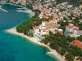 Na Riwierze Makarskiej największe „turystyczne” triumfy święci Baška Voda. Od lat jest to jeden z najpopularniejszych kurortów nadmorskich na chorwackim wybrzeżu. Otoczenie jest bajeczne - z jednej strony gorące, jasnoniebieskie wody Adriatyku, z drugiej - potężne, ośnieżone szczyty masywu Biokovo. Wakacje w takim miejscu nie mogą być nudne!

W okresie największego przesilenia turystycznego w Bašce przebywa najwięcej podróżnych na całej Riwierze Makarskiej.


Atrakcje turystyczne


Na początek kilka tez udowadniających, że Baška Voda to prawdziwy raj dla podróżników - tutaj każdy znajdzie coś odpowiedniego dla siebie. Turyści chętnie wykupują rejsy organizowane na pobliskie wyspy: Brač oraz Hvar - po dotarciu na miejsce można zwiedzić naprawdę ciekawe zakątki chorwackiego wybrzeża, dodatkowo podziwiając piękny Adriatyk z pokładu statku. Wycieczkę po okolicy warto zacząć od nadmorskiej promenady, która prowadzi do pobliskiej Brely. Amatorzy sportów wodnych również znajdą coś dla siebie. Wybór jest całkiem spory: od nurkowania, poprzez windsurfing, surfing, paragliding po narty wodne oraz inne atrakcje. Baška to prawdziwy raj dla poszukiwaczy przygód - w dorzeczu Cetiny można zorganizować niezapomniany spływ raftingowy. W kurorcie Baška Voda można również zagrać w piłkę ręczną na jednym z boisk na plaży, spróbować swoich sił w tenisie ziemnym oraz mini golfie. Te i inne sporty to tylko część atrakcji jakie czekają na turystów po przybyciu do Baškiej Vody. Wieczorne godziny wypełnią nam tańce i zabawy w centralnej części miasteczka - pełno tutaj urokliwych tawern, restauracji z muzyką na żywo, pubów oraz zakamarków, które sprzyjają wyciszeniu i spokojnej rozmowie.

Największą architektoniczną atrakcją w okolicy jest zabytkowy kościółek św. Lovrego z połowy XVIII w. oraz nieco nowszy i większy - św. Mikołaja Podróżnika (1889 r.).

 
Wycieczki fakultatywne


Spędzając wakacje w Baškiej Vodzie nie można pominąć odwiedzin w pobliskiej Breli. Turyści przyjeżdżają tutaj zwabieni przede wszystkim czystymi, żwirowymi plażami oraz nowoczesną bazą noclegową. Obowiązkowym punktem wycieczki musi być również miasteczko Makarska, centrum kulturalne i turystyczne w całym regionie. Przy głównym placu miasta - plac Andrija Kačića Miošića - znajduje się chętnie odwiedzana katedra św. Marka z XVIII w. W miesiącach letnich Makarska obfituje w różne imprezy kulturalne, koncerty, wystawy itp.

Ważnym miastem na wybrzeżu jest również zabytkowy Split. Jedną z największych atrakcji w mieście jest Pałac Dioklecjana, pochodzący z czasów rzymskich. Warto zajrzeć do Galerii Meštrovicia, lokalnego rzeźbiarza.

Wakacje na Riwierze Makarskiej muszą zaobfitować w wycieczki do mniej znanych miasteczek na wybrzeżu. Tutaj na uwagę zasługuje m.in. Drvenik, Promajna, Podgora, Zaostrog, Brist, Gradac czy Podaca.


Noclegi


Baza noclegowa Baškej Vody jest świetnie przygotowana. Obok luksusowych kompleksów wypoczynkowych znajdziemy tutaj także i tańsze oferty - pensjonaty i prywatne kwatery. Dużą popularnością wśród turystów cieszy się np. Pension Palac. W 3-gwiazdkowym ośrodku panuje kameralna atmosfera - nie trudno się temu dziwić, jeśli w pensjonacie znajduje się zaledwie 10 pokoi. Palac położony jest tuż przy żwirowej plaży. Do dyspozycji gości pozostaje bezprzewodowy, bezpłatny Internet, restauracja, bar z lokalnymi napojami alkoholowymi oraz bezpłatne miejsca parkingowe.

Równie ciekawie prezentuje się Villa Marija, położona nieco ponad 100 m od pięknej plaży. Znajdziemy tutaj komfortowo urządzone apartamenty, w pełni wyposażone, z bezprzewodowym Internetem, telewizją satelitarną i balkonami. W obszernym ogrodzie znajdziemy miejsce do grillowania. Blisko stąd do centrum miasta, gdzie czeka nas więcej atrakcji i możliwości spędzania wolnego czasu.

Luksusowe pokoje oraz dbałość o każdy szczegół są zaletami 4-gwiazdkowego hotelu Horizont. Ośrodek wypoczynkowy położony jest kilkadziesiąt metrów od żwirowej plaży oraz kilka minut spacerem od samego centrum miasteczka. Wśród licznych hotelowych udogodnień znajdziemy kort tenisowy, saunę, łaźnię turecką, centrum fitness, salon gier, solarium, salon odnowy biologicznej, 2 baseny (kryty i zewnętrzny), na najmłodszych gości czeka plac zabaw. W hotelowej restauracji podawane są przysmaki z tradycyjnej kuchni chorwackiej ale także europejskiej.

Turyści chętnie wybierają 4-gwiazdkowy Aparthotel Milenij. Goście znajdą tutaj wszystko, czego mogą potrzebować: bar przy plaży, Spa, jacuzzi, sauna, centrum fitness, kafejka internetowa, basen - to tylko część z hotelowych atrakcji. Posiłki serwowane są w głównej restauracji (z tarasem), można również odwiedzić tutejszą pizzerię.

Prawdziwą hotelową „perełką” jest 4-gwiazdkowy ośrodek Croatia, odnowiony w 2008 r. Charakterystyczna elewacja budynku przypomina gościom o iście śródziemnomorskim klimacie miejsca. Wewnątrz natomiast czeka nas pełen komfort wypoczynku i relaks. Hotelowa obsługa zadba, by spędzone w tym miejscu wakacje były niezapomniane. W ośrodku znajduje się biblioteka, taras słoneczny, wypożyczalnia rowerów, sejf, urządzenia biurowe, bezpłatny Internet oraz miejsca parkingowe.


Pogoda


Riwiera Makarska oddzielona jest od reszty „świata” masywem Biokovo, który w dużej mierze decyduje o kształcie panującego tutaj klimatu - przede wszystkim na wybrzeże nie docierają masy kontynentalnego powietrza. Zima ma łagodny przebieg, lato natomiast charakteryzuje się bardzo wysokimi temperaturami powietrza i wody w morzu oraz zbawiennym, chłodzącym w upalne dni wiatrem - maestralem. W miesiącach wakacyjnych (między czerwcem a październikiem) średnie temperatury powietrza utrzymują się ponad 20 kreską - podobnie zresztą przedstawia się temperatura wody.