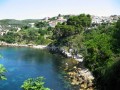 Informacje podstawowe


Ten położony nad Adriatykiem, czarnogórski kurort słynie z szerokich piaszczystych plaż, gościnności mieszkańców i malowniczych gajów oliwnych. Jest to najdalej wysunięta na południe miejscowość w kraju, którą zamieszkują głownie Albańczycy (72 %), a w sezonie - turyści. Ulcinj to bowiem, tuż po Budvie, najchętniej odwiedzany zakątek w niepodległej od 2006 roku Czarnogórze. Co ciekawe, w ubiegłym roku, popularny amerykański dziennik New York Times, uplasował Ulcinj pośród 31 topowych wakacyjnych zakątków 2010 roku.


Historia i zabytki


Liczące sobie nieco ponad 10 tysięcy mieszkańców tereny Ulcinj, były zasiedlane już w epoce brązu, głównie przez plemiona Illyryjskie, o czym świadczą bogate znaleziska archeologiczne. Początki miasta datuje się natomiast na V wiek przed Chrystusem - kiedy ziemie obecnej Czarnogóry podbili Grecy. Wokół osady wybudowano wtedy tzw. mur cyklopowy, którego pozostałości podziwiać możemy po dziś dzień. Później władzę nad terytorium przejęli Rzymianinie. Miasto uzyskało wtedy specjalne przywileje, a także nową, łacińską nazwę - Olcinium.
 
W XII wieku, Ulcinj - a właściwie wtedy jeszcze Olciunium - jako część Bizancjum, zostało podbite przez słowiańskiego księcia Nemanja i to właśnie za czasów jego panowania, miasto przeżyło największy rozkwit. Później doskonale prosperowało jako popularny resort oraz mennica. W pierwszych latach XV wieku tereny przeszły pod władanie Księstwa Weneckiego (Ulcinj nazywane było wtedy Dulcigno) i było zaliczane do tzw. Weneckiej Albanii. Do miasta sprowadzano wówczas wielu afrykańskich niewolników, czemu kres położyło przejęcie Weneckiej Albanii przez Turków i imperium Osmańskie. Dopiero w wyniku decyzji kongresu berlińskiego w 1878 roku, ziemie Ulcinj stały się integralną częścią Czarnogóry.

Jak nie trudno przewidzieć, w mieście o tak bogatej przeszłości, wprost roi się od zabytków. Miłośnicy historii - ale nie tylko - będą zachwyceni spacerem wąskimi, brukowanymi uliczkami starego miasta, gdzie znajdują się doskonale zachowane budynki, których ściany pamiętają jeszcze epokę średniowiecza!
 
Godnymi uwagi są szczególnie świątynie - w tym biała cerkiew św. Mikołaja z końca XIX wieku, meczet Namazdjah z 1728 roku, a także nietypowa, czteroboczna wieża obronna i wieża zegarowa (Sat Kula). Poza tym, to właśnie z położnej na wzgórzu, odbudowanej po trzęsieniu ziemi w 1979 roku, starówki, rozciąga się jeden z najpiękniejszych w okolicy krajobraz - widok skąpanego w słońcu, adriatyckiego wybrzeża. 


Atrakcje turystyczne


Jednym z najchętniej odwiedzanych miejsc w regionie Ulcinj jest malownicza wysepka Ada, położona w maleńkiej delcie rzeki Bojana. Co ciekawe wysepka powstała dopiero pod koniec XIX wieku, kiedy to u wybrzeży obecnej Czarnogóry, zatonął statek, a gromadzący się wokół wraku piach utworzył wyspę o powierzchni 5 km kwadratowych! Dziś Ada to jedna z najpopularniejszych w Europie, a może nawet na świecie - plaż dla naturystów.

W samym miasteczku warto udać się do znajdującego się Muzeum Archeologicznego i stamtąd rozpocząć krótką wycieczkę śladami przeszłości Ulcinj.

Miłośnicy przyrody będą zachwyceni rezerwatem dla ptaków - zlokalizowanym w okolicach jeziora Šaško. W pobliżu znajdują się ruiny ośmiu kościołów, z którymi związanych jest wiele miejscowych legend. Doskonałą formą spędzenia wolnego czasu będzie także spływ rzeką Tarą oraz wycieczka to położonych w pobliżu mokradeł Milena i Salina. 


Plaże


W Ulcinj każdy znajdzie coś dla siebie. Wczasowicze, którzy lubią towarzystwo oraz liczne rozrywki będą zadowoleni wypoczynkiem na piaszczystej plaży miejskiej, która tętni życiem od rana do wieczora. Po drugiej stronie półwyspu znajduje się nieco spokojniejsza plaża Liman, a na wschód od miasteczka znajduje się najpopularniejsza plaża w całej Czarnogórze i jedno z chętniej odwiedzanych kąpielisk na całych Bałkanach. Velika - bo o niej mowa ma długość aż 13 kilometrów i szerokość około 60 metrów. 


Noclegi i transport


Najbardziej przystępną ofertą, jeśli chodzi o noclegi, dysponują rzecz jasna kwatery prywatne. Pensjonaty są nawet kilkakrotnie tańsze, niż te w Polsce. (około 5-10 euro za osobę). Coraz popularniejsze są też kampingi - zwłaszcza wśród ludzi młodych, ale nie jest to regułą. Niejednokrotnie autocampem chętnie podróżują całe rodziny z dziećmi. Jest to o tyle wygodne, że wielu wczasowiczów do Czarnogóry przyjeżdża samochodem. Droga wiedzie najczęściej przez Słowację, Austrię, Słowenię i Chorwację - nie jest zbyt długa, ani męcząca, a ewentualne znużenie oczekiwaniem dojazdu do upragnionej Czarnogóry, rekompensują piękne widoki i ciekawe miejsca, które mijamy podczas trasy.
 
W Ulcinj nie brakuje też luksusowych hoteli z ofertą all inclusive. Większość z nich znajduje się na starówce, wyglądem przypominają one małe pałace. Gwarantują gościom doskonałe wyżywienie, pokoje z widokiem na morze oraz obsługę na najwyższym, europejskim poziomie. 


Wycieczki fakultatywne


Czarnogóra to kraj niewielki i gościnny. Podczas urlopu można odwiedzić wszystkie, najbardziej interesujące zakątki w państwie oraz poznać uroki Bałkanów. Warto zwiedzić m.in. pobliską Budvę, Podgoricę, czy Herceg Novi - z którego regularnie kursują turystyczne stateczki do Dubrovnika. Uwagi godna jest również wycieczka w malownicze góry Durmitor, kanion Tary, Stary Bar, a także jeziora Piwskie i Skadarskie. 


Pogoda, klimat, średnie temperatury


Czarnogóra to państwo o zróżnicowanym klimacie. Jej południowa część - w której położone jest miasteczko Ulcinj leży w strefie klimatu śródziemnomorskiego. Pogoda jest raczej stabilna, cechuje ją duża liczba dni słonecznych w roku oraz niewielkie opady. Średnia temperatura latem to około 25°C, temperatura wody sięga w tym okresie 20-22°C. W styczniu termometry wskazują wielkości rzędu 9°C.